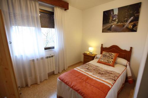 a bedroom with a bed and a window at Hostal San Blas in La Alberca