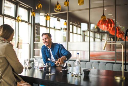 a man sitting at a table in a restaurant at Apex City of Bath Hotel in Bath