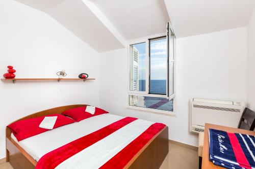 a white bedroom with a bed and a window at Apartment Marko Dubrovnik in Dubrovnik
