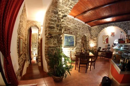 a room with a stone wall and a dining room at Nerodivino B&B in Torchiara