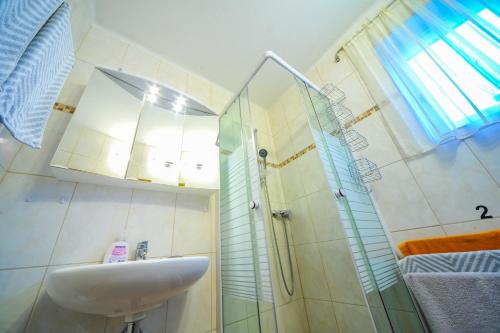 een badkamer met een wastafel en een douche bij Privatzimmer Haus Erika in Sankt Peter-Freienstein