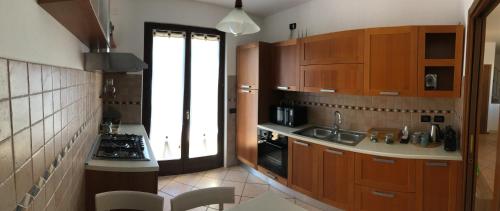 a kitchen with wooden cabinets and a sink and a stove at Casa Dany in Lugagnano