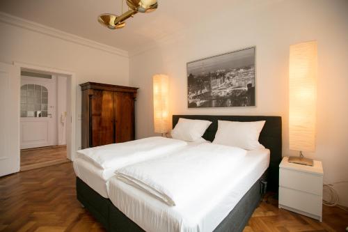 ein Schlafzimmer mit einem großen Bett mit weißer Bettwäsche in der Unterkunft Palazzo am Dom in Regensburg