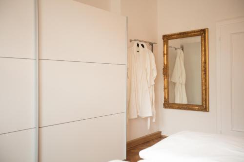 a white room with a mirror and a closet at Palazzo am Dom in Regensburg