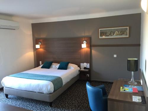 una camera d'albergo con letto, tavolo e sedia di Le Galion Hotel et Restaurant Canet Plage - Logis a Canet-en-Roussillon