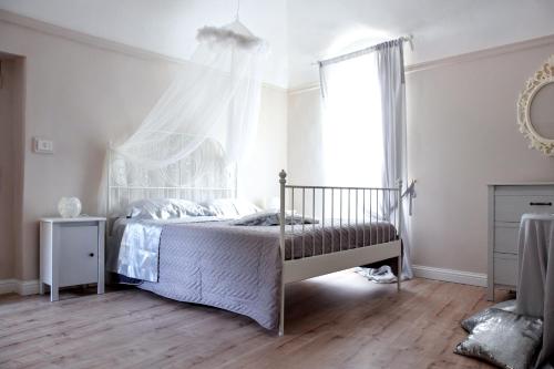 - une chambre blanche avec un lit à baldaquin dans l'établissement B&B Al Castello di Lettere, à Lettere