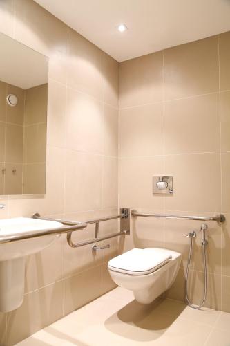 a bathroom with a toilet and a sink at Vitória Hotel Express Dom Pedro in Campinas