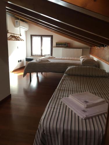 a room with three beds and a window at Casa Dany in Lugagnano