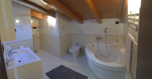 a bathroom with a tub and a toilet and a sink at Casa Dany in Lugagnano
