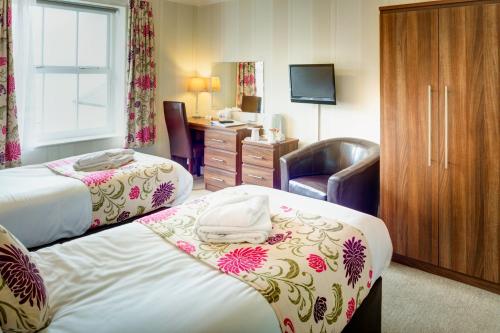 a hotel room with two beds and a desk at Lord Haldon Country Hotel, Sure Hotel Collection by Best Western in Exeter