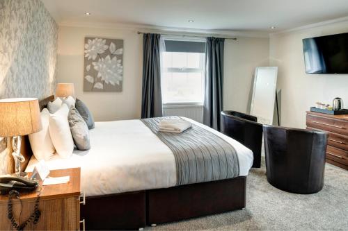a bedroom with a bed and a desk and a television at Lord Haldon Country Hotel, Sure Hotel Collection by Best Western in Exeter