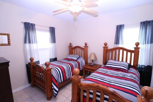 two twin beds in a room with windows at Los Cabos III Condominiums in South Padre Island
