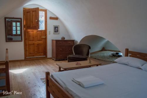 a bedroom with a bed and a chair and a table at Siskosplace in Oia