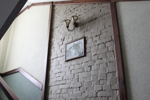 a hallway with a brick wall with a picture on it at Nashe Misto Guest House in Kovelʼ