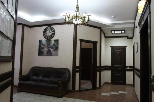 a living room with a couch and a clock on the wall at Nashe Misto Guest House in Kovelʼ
