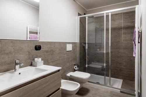 a bathroom with a shower and a toilet and a sink at Lake Como Apartments in Lecco