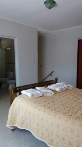 a bedroom with a bed with four pillows on it at Navarro Departamentos Temporarios in Navarro