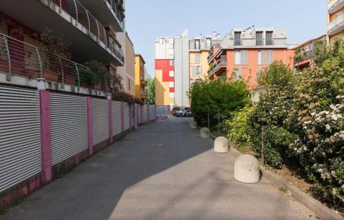 an alley with buildings and trees and bushes at Hotel Greco in Milan