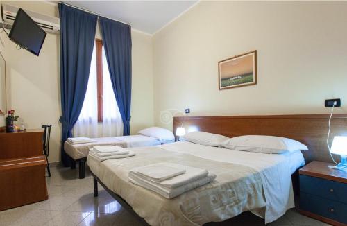 1 dormitorio con 2 camas con cortinas azules en Hotel Greco, en Milán