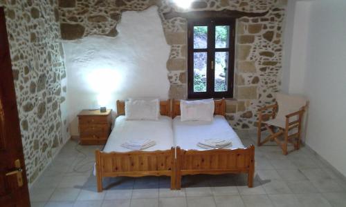 a bedroom with a bed in a stone room at Traditional House Koukounara in Kissamos