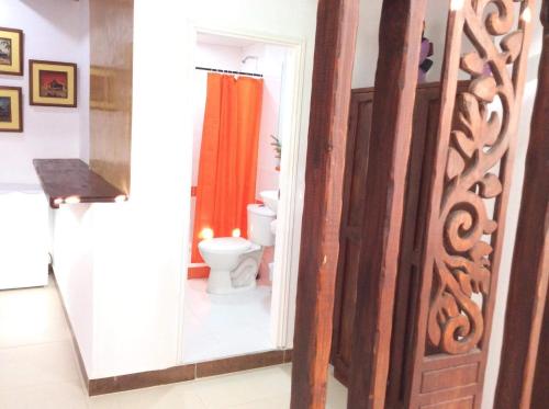 a bathroom with a toilet and a shower door at La Posada De Lulú in San Andrés