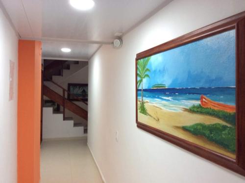 a hallway with a painting of a beach on the wall at La Posada De Lulú in San Andrés