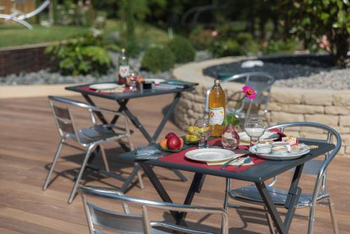 two tables with plates of food and a bottle of wine at Domaine et chambres d'Hôtes des Fées in Pretin