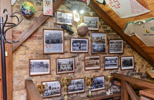 a wall of pictures on a brick wall with trophies at Nashe Misto Guest House in Kovelʼ