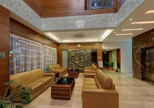 a living room with couches and tables at Parijatha Gateway in Bengaluru