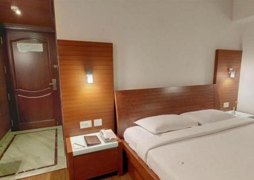 a bedroom with a bed with a mirror and a door at Parijatha Gateway in Bengaluru
