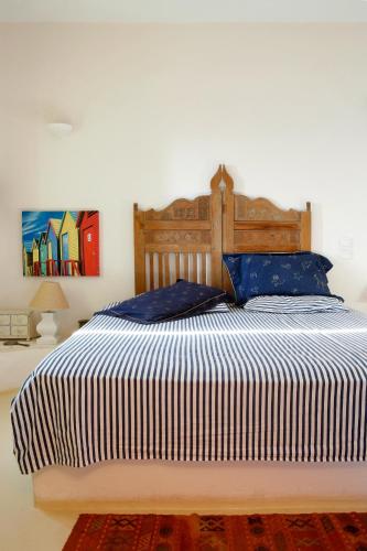 a bedroom with a large bed with blue pillows at Villa Martha in Kea in Koundouros