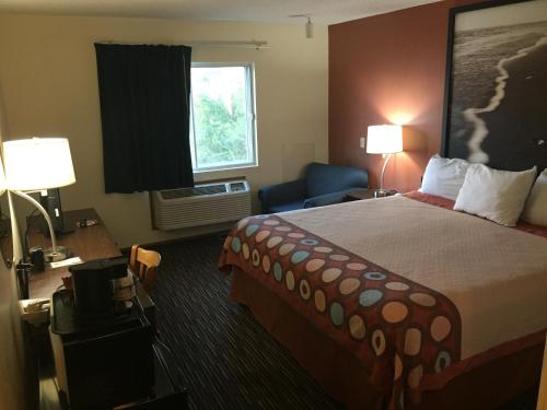 a hotel room with a bed and a window at Super 8 by Wyndham College Station in College Station