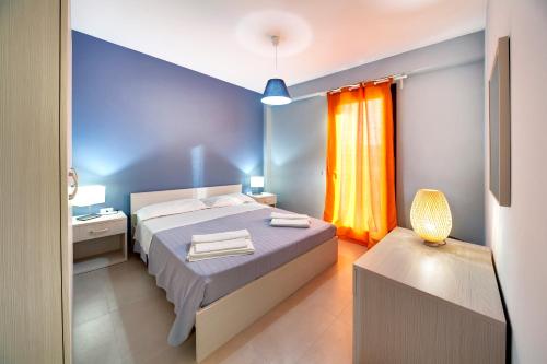 a bedroom with a bed and a yellow curtain at Borgo Vigata in Punta Secca