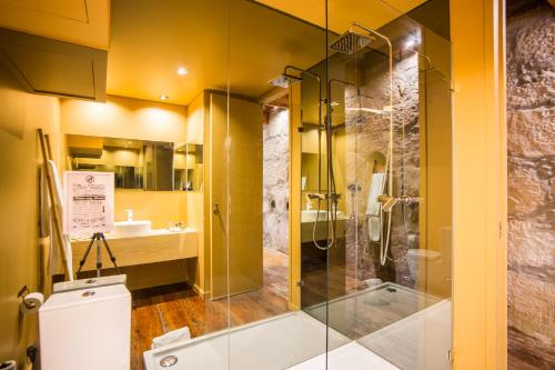 Un baño con ducha de cristal y un inodoro. en Laurear Guest House, en Oporto