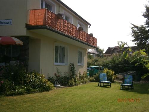 ein Haus mit einem Balkon und zwei Stühlen im Hof in der Unterkunft Haus Steinbach in Kellenhusen