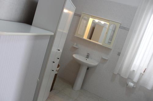 トッレ・スーダにあるCase Vacanza Rossellaの白いバスルーム(シンク、鏡付)