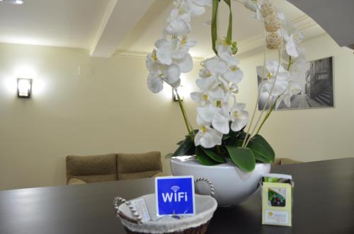 a table with a vase with white flowers on it at Albergue del Peregrino in Arzúa