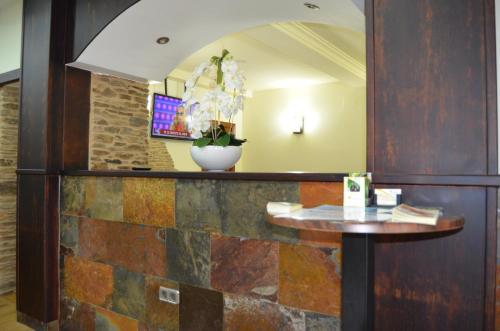 un restaurante con una pared de piedra y una mesa en Albergue del Peregrino, en Arzúa