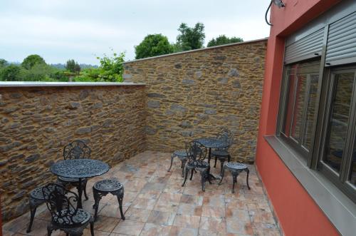 a group of tables and chairs on a patio at Albergue del Peregrino in Arzúa