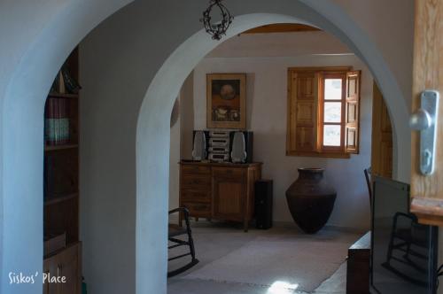 an archway in a room with a table and a window at Siskosplace in Oia