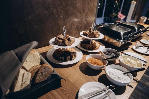 een tafel met verschillende soorten brood en kommen eten bij Noble Boutique Hotel in Loetsk