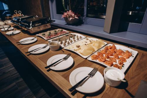 een tafel met borden en keukengerei en eten erop bij Noble Boutique Hotel in Loetsk