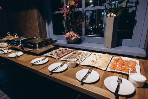 een buffet met borden en eten op tafel bij Noble Boutique Hotel in Loetsk