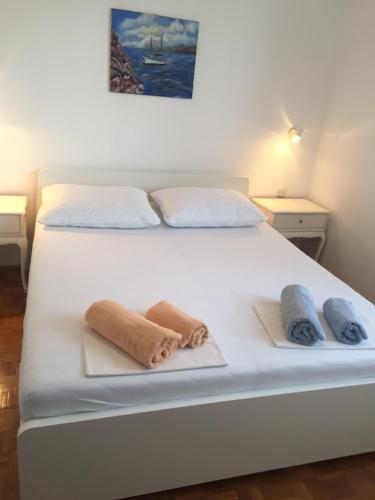 a white bed with towels on top of it at Schreng Apartments in Malinska