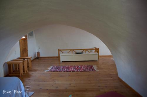a room with a bed and a rug on a wooden floor at Siskosplace in Oia