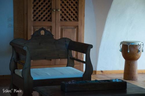 a wooden chair sitting in a room with a bowl at Siskosplace in Oia