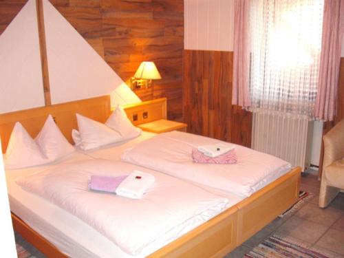 ein Schlafzimmer mit einem großen Bett mit zwei Handtüchern darauf in der Unterkunft Landgasthof Schweizerhof in Wonneberg