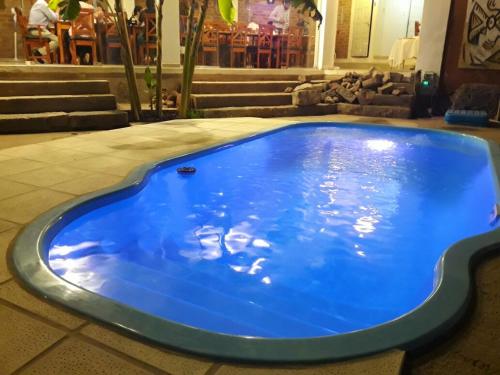 a large blue swimming pool in a room with stairs at El Viejo Molino in Chilecito