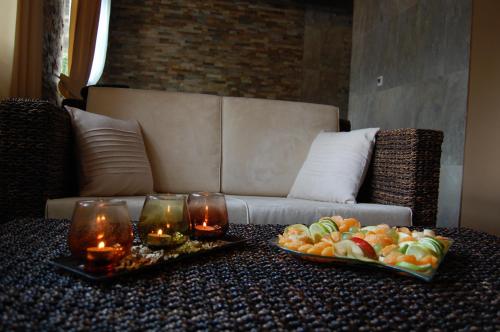 a table with a plate of fruit and candles on a couch at Hotel RICHTR in Frýdek-Místek