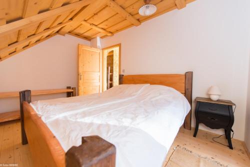 a bedroom with a bed and a wooden ceiling at Koča na Planini in Planina pod Sumnikom